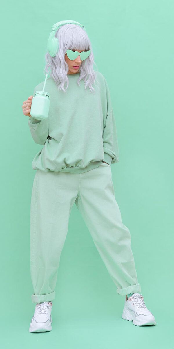 Hipster teen girl posing over wall. Urban style. Fresh mint monochrome aesthetic