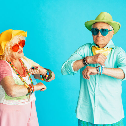Beautiful senior old couple wearing fancy party clothes acting in studio on a colored background. Beautiful senior old couple wearing fancy party clothes acting in studio on a colored background. Conceptual image about third age and seniority, old people feeling young inside.