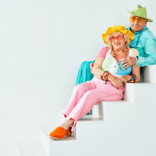 Beautiful senior old couple wearing fancy party clothes acting in studio on a colored background. Beautiful senior old couple wearing fancy party clothes acting in studio on a colored background. Conceptual image about third age and seniority, old people feeling young inside.