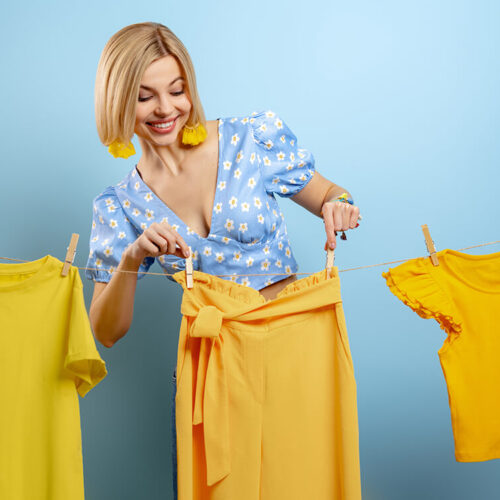 beautiful-young-woman-hanging-her-colorful-clothes-2023-11-27-04-54-38-utc