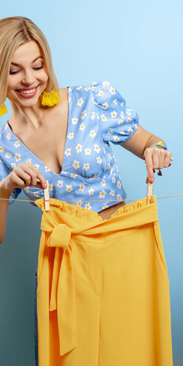 beautiful-young-woman-hanging-her-colorful-clothes-2023-11-27-04-54-38-utc