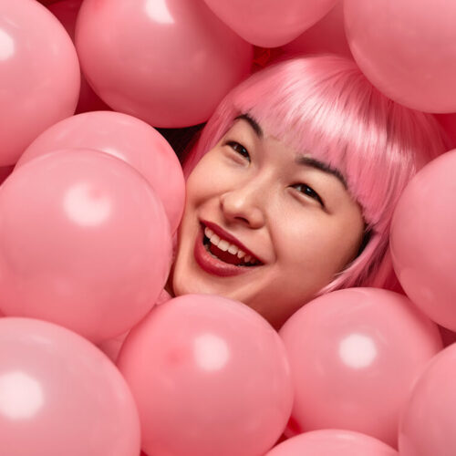cheerful-asian-female-in-heap-of-balloons-2023-11-27-04-56-37-utc
