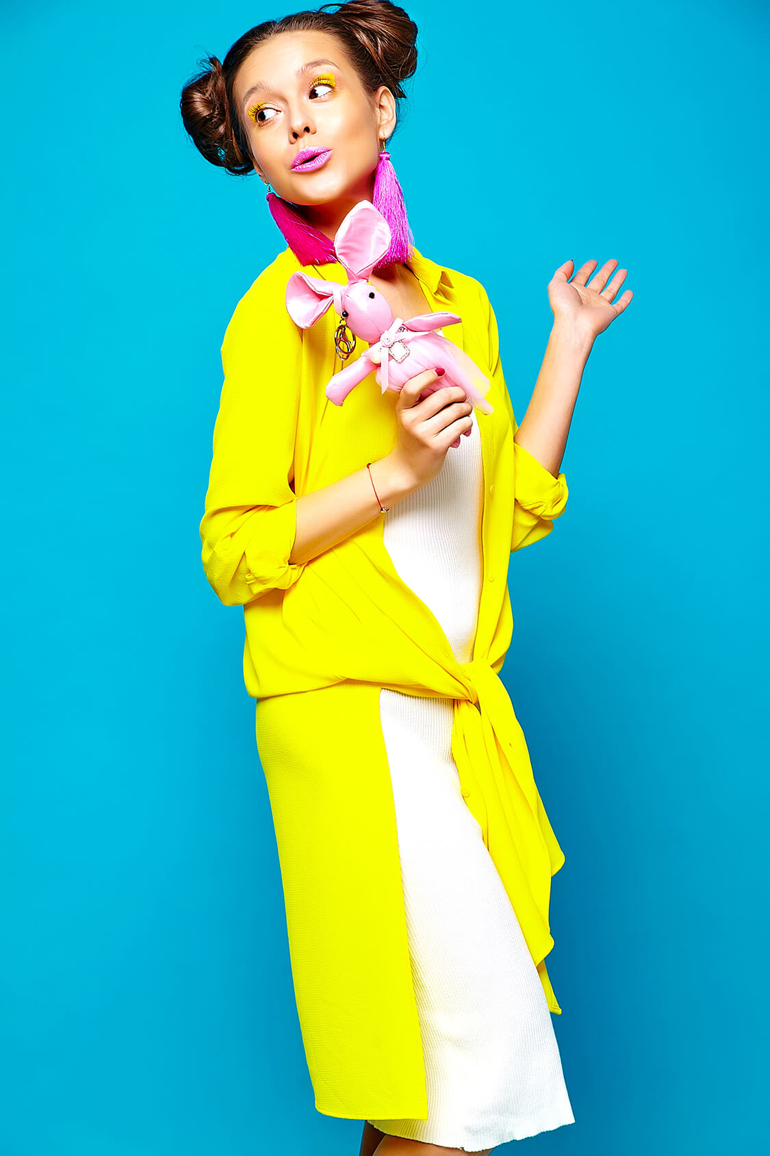 Portrait of young stylish woman with creative hairstyle posing in studio