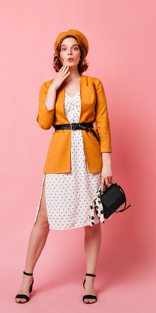 Full length view of jocund french lady with handbag. Studio shot of trendy slim girl in yellow beret.