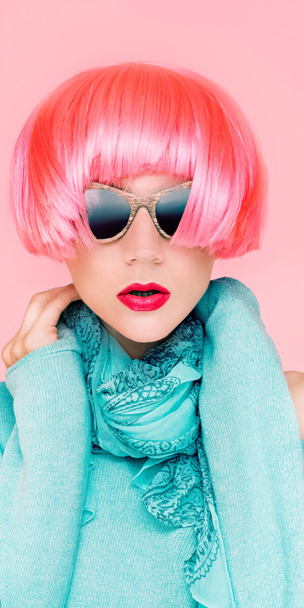 Glamorous fashion lady in pink wig on pink background