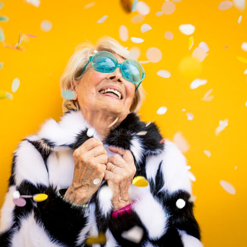 Happy grandmother posing on colored backgrounds. Woman having fun and celebrating