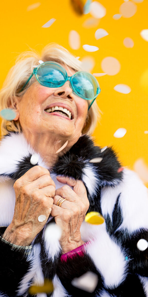 Happy grandmother posing on colored backgrounds. Woman having fun and celebrating