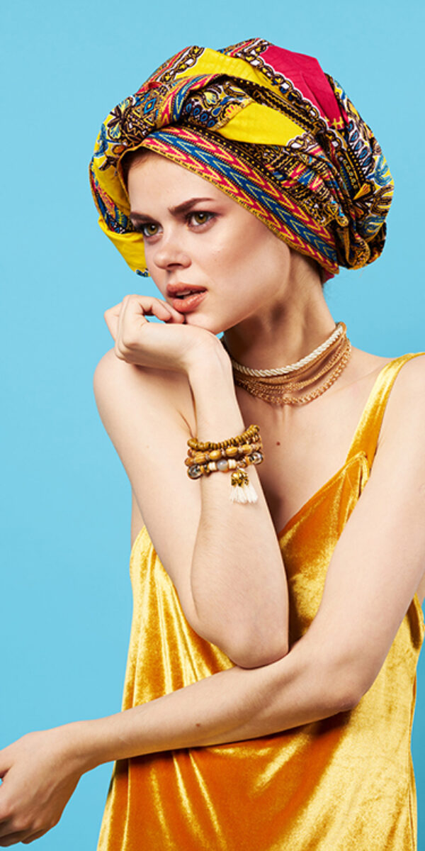 pretty woman in multicolored turban attractive look Jewelry smile isolated background. High quality photo