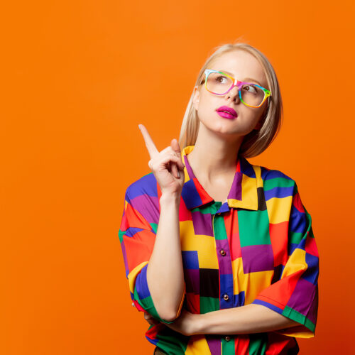 Style blonde in 90s clothes and rainbow glasses Style blonde in 90s clothes and rainbow glasses on orange background