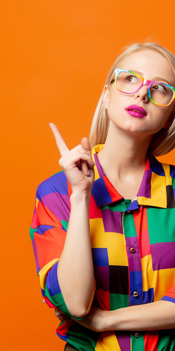 Style blonde in 90s clothes and rainbow glasses on orange background