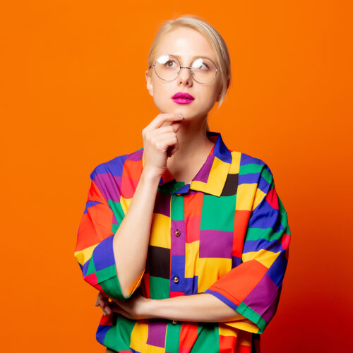 Style blonde in 90s shirt and glasses Style blonde in 90s shirt and glasses on orange background