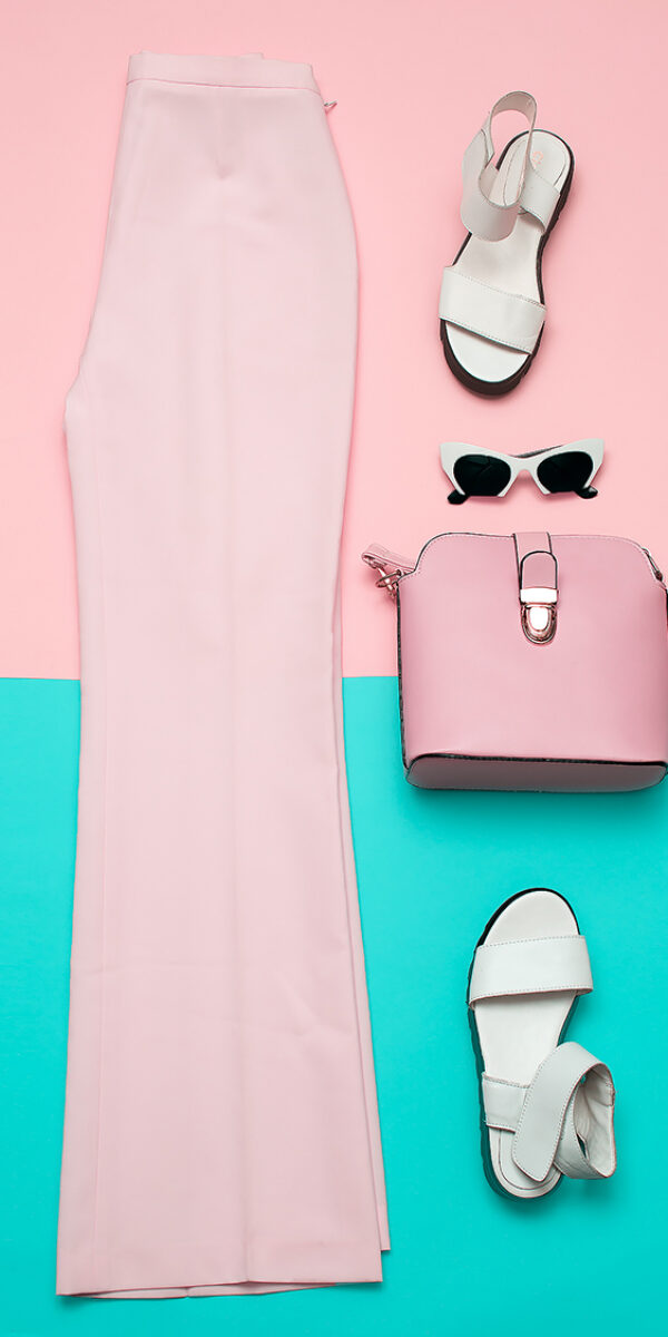 Stylish pink clothing for ladies. Fashion trousers and accessories. Top view