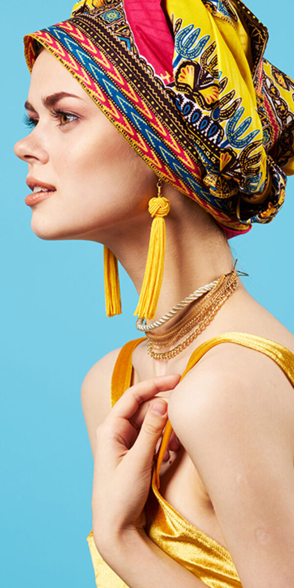 woman in multicolored turban luxury ethnicity blue background. High quality photo