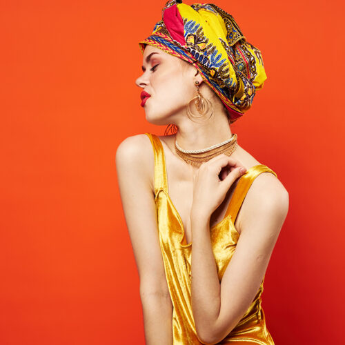 woman with multicolored turban decoration red lips charm emotions red background. High quality photo