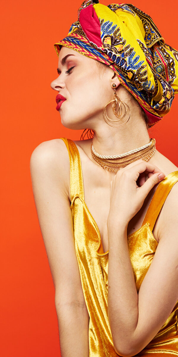 woman with multicolored turban decoration red lips charm emotions red background. High quality photo